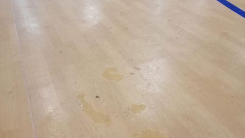 Agua de una gotera en la pista del Polideportivo de La Hoya de Elche.