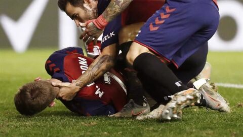 Los jugadores de Osasuna Rub&eacute;n Garc&iacute;a (c) y Chimy &Aacute;vila (d) acuden en ayuda de su compa&ntilde;ero Marc Cardona