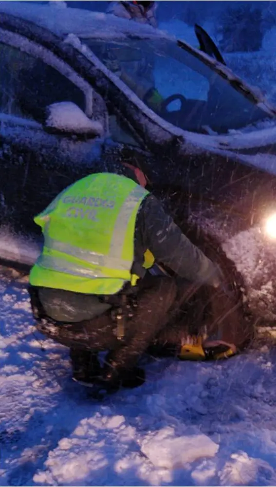 Una agente de la Guardia Civil auxilia a un vehículo atrapado en la nieve en Villena.