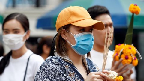 Una mujer se protege con una mascarilla