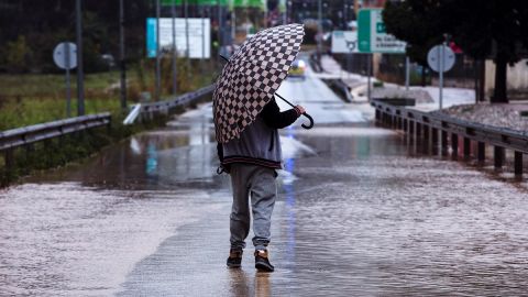 Un hombre se resguarda de la lluvia con un paraguas