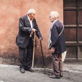 Dos ancianos frente a un domicilio