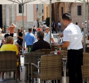 Un camarero recoge una mesa Un camarero recoge una mesa