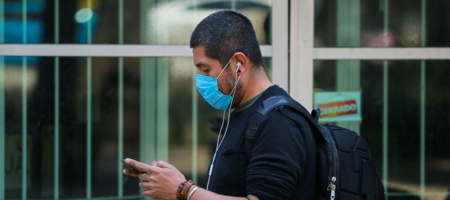 Coronavirus | Un hombre con mascarilla consulta su teléfono Coronavirus | Un hombre con mascarilla consulta su teléfono