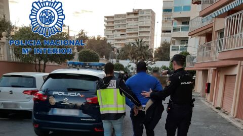 Agentes de la Polic&iacute;a Nacional con uno de los detenidos.
