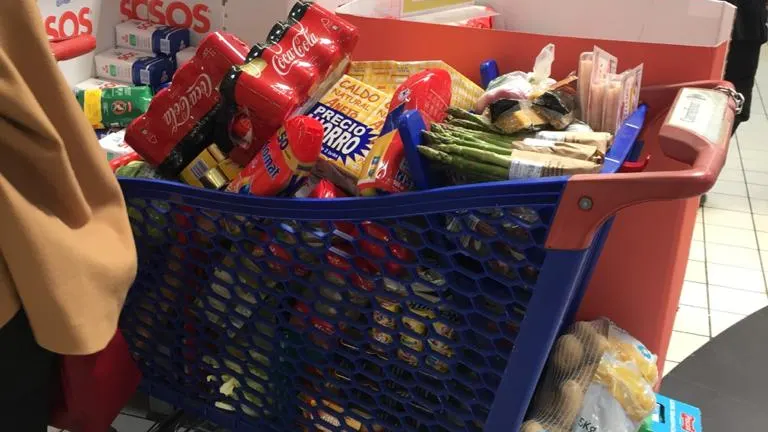 Un carrito de la compra lleno en un supermercado Un carrito de la compra lleno en un supermercado