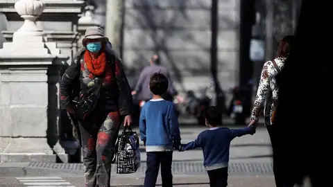 Un par de niños cruzan una calle en Madrid Un par de niños cruzan una calle en Madrid