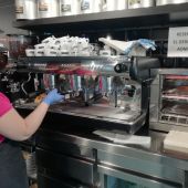 Trabajadora de una cafetería de Elche con guantes para poner barrera al coronavirus.