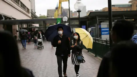 Dos ciudadanos pasean por Sidney con mascarillas puestas Dos ciudadanos pasean por Sidney con mascarillas puestas