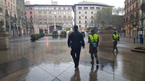 Un agente de la Polic&iacute;a Nacional, junto a dos miembros del Ej&eacute;rcito, vigilando las calles de Palma.