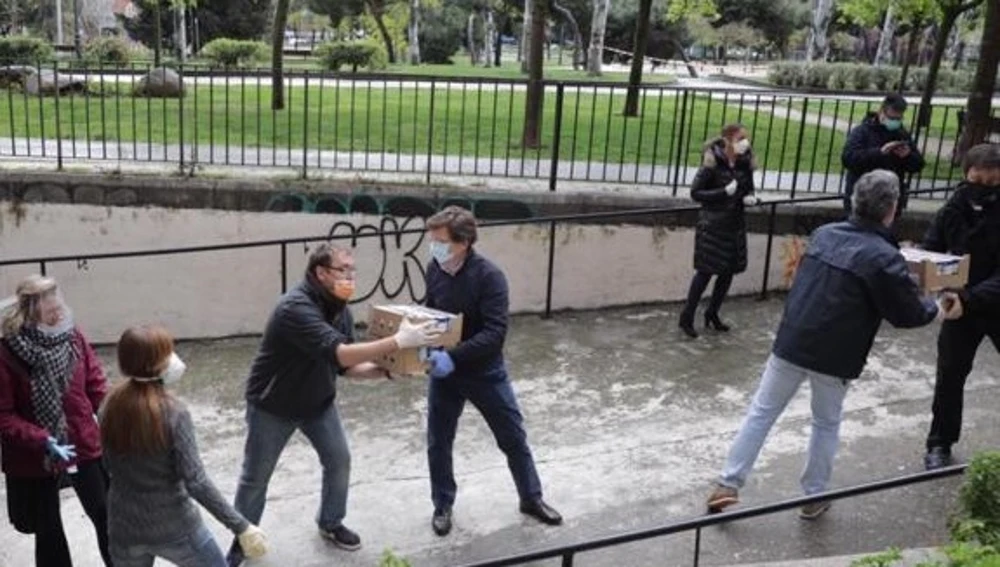 El alcalde de Madrid, José Luis Martínez-Almeida, ayuda a descargar unas cajas con alimentos