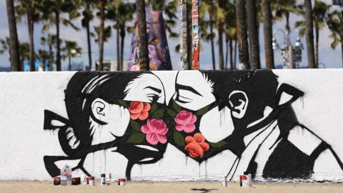 Graffiti de una pareja bes&aacute;ndose
