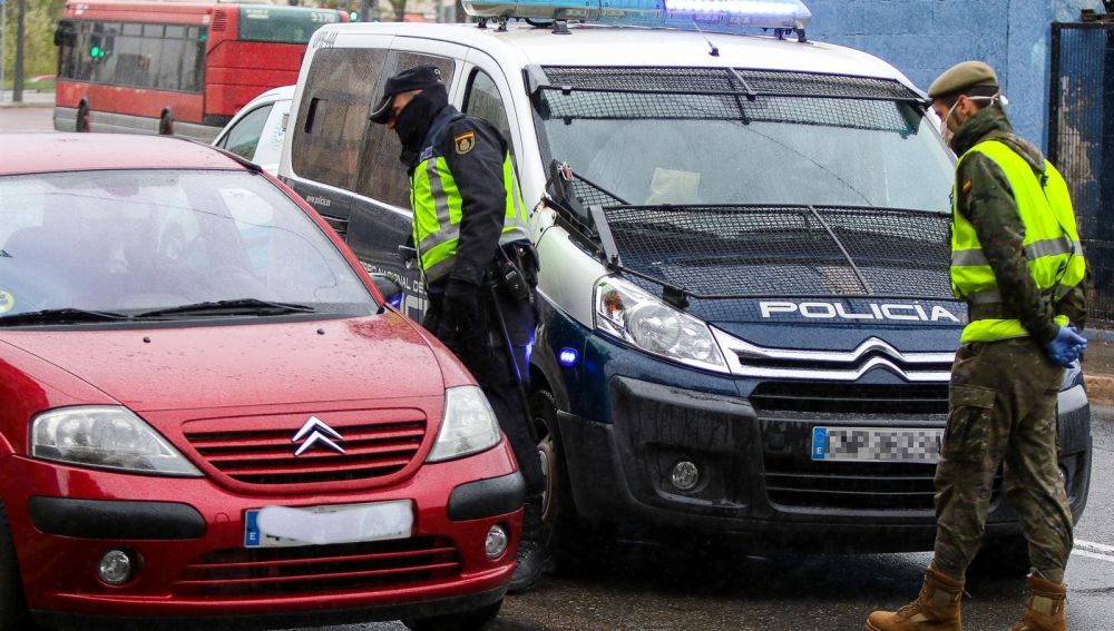 Un militar del Ejército y un agente de la Policía Nacional realizan controles de tráfico a la salida de la ciudad durante un viernes del estado de alarma