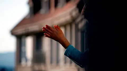 Imagen de una mujer aplaudiendo en un balcón durante la crisis por coronavirus Imagen de una mujer aplaudiendo en un balcón durante la crisis por coronavirus