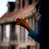 Imagen de una mujer aplaudiendo en un balcón durante la crisis por coronavirus