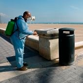 Un operario desinfecta una papelera ante una playa de la Malvarrosa (Valencia)