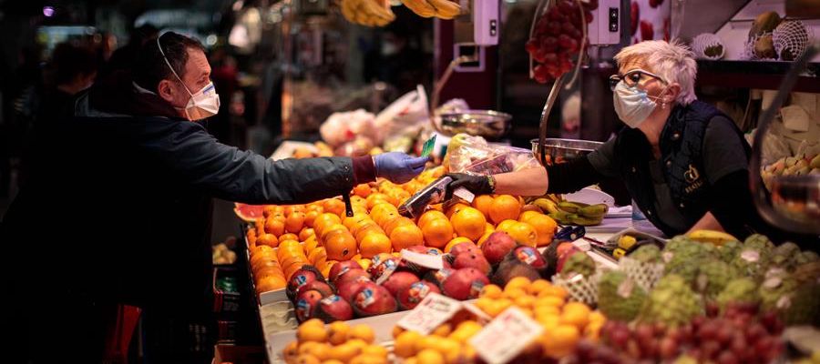 Una persona compra en un puesto de frutas del Mercado Central de Valencia