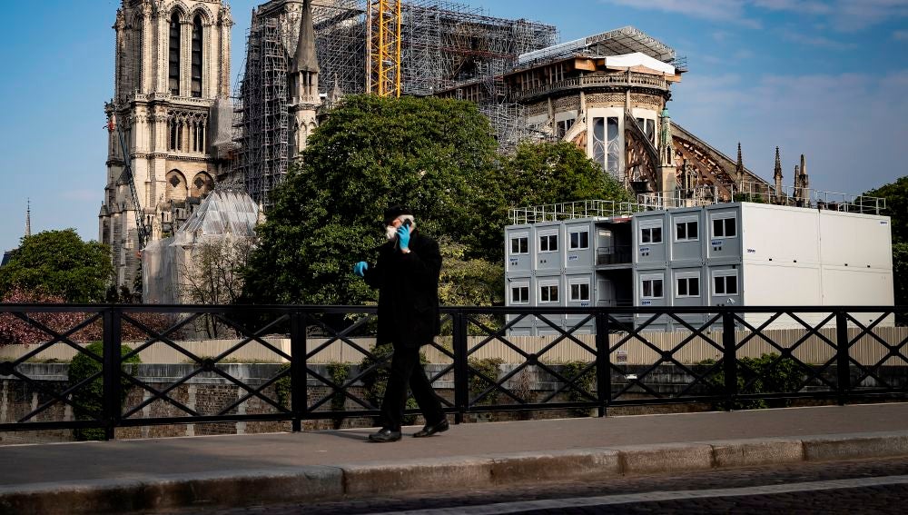 Imagen de un hombre andando en pleno confinamiento por coronavirus en París, Francia