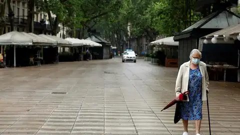 Una mujer protegida con mascarilla pasea por las Ramblas Una mujer protegida con mascarilla pasea por las Ramblas