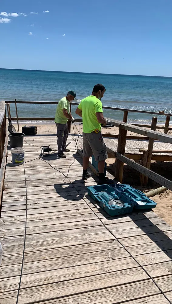 Trabajos de reparación de una pasarela en una playa de Elche. Trabajos de reparación de una pasarela en una playa de Elche.