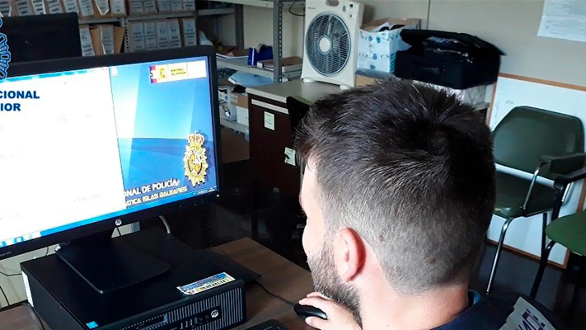 Un policía nacional manejando un ordenador