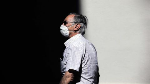 Una persona protegida con mascarilla recorre una calle en Valencia.
