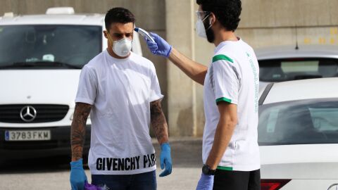 Un miembro del cuerpo m&eacute;dico del Betis toma la temperatura a Cristian Tello.