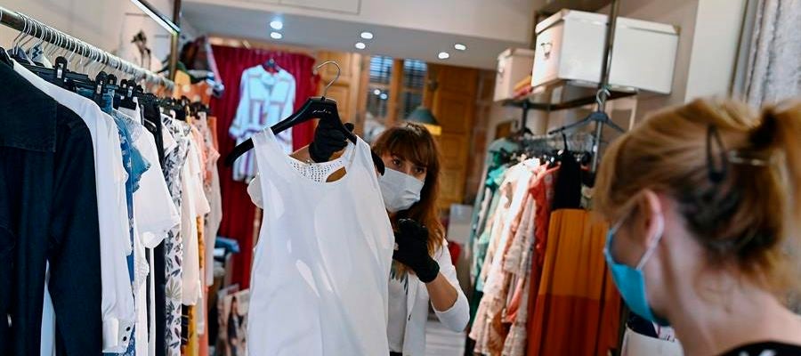 Una trabajadora muestra ropa a una clienta en un comercio de Alcalá de Henares, Madrid Una trabajadora muestra ropa a una clienta en un comercio de Alcalá de Henares, Madrid
