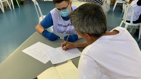 Un voluntario y un usuario en el taller de escritura 