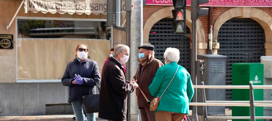 Personas mayores con mascarillas conversan en la calle Personas mayores con mascarillas conversan en la calle