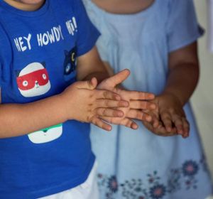 Dos niños de desinfectan las manos con gel hidroalcohólico Dos niños de desinfectan las manos con gel hidroalcohólico