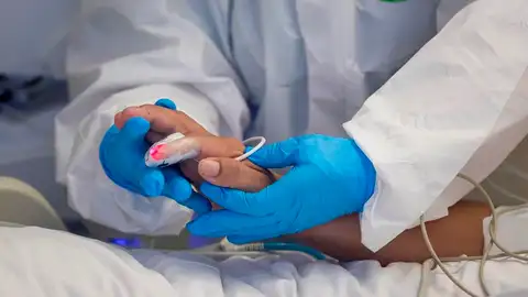 Un sanitario atiende a un paciente hospitalizado por coronavirus. Un sanitario atiende a un paciente hospitalizado por coronavirus.