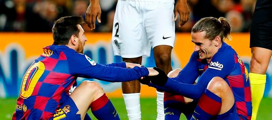Messi y Griezmann se ayudan a levantarse del césped en un partido con el Barça. Messi y Griezmann se ayudan a levantarse del césped en un partido con el Barça.