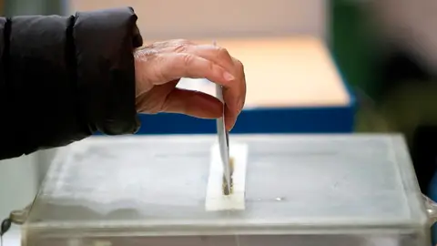 Imagen de archivo de una persona depositando su voto en una urna Imagen de archivo de una persona depositando su voto en una urna
