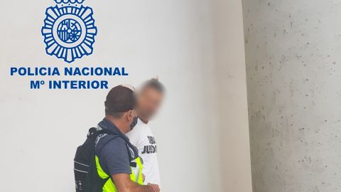 Un agente de la Polic&iacute;a Nacional con el ciudadano alem&aacute;n detenido en el Aeropuerto Alicante-Elche.