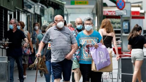 Varias personas en los alrededores del mercado del barrio de Collblanc de L'Hospitalet (Barcelona)