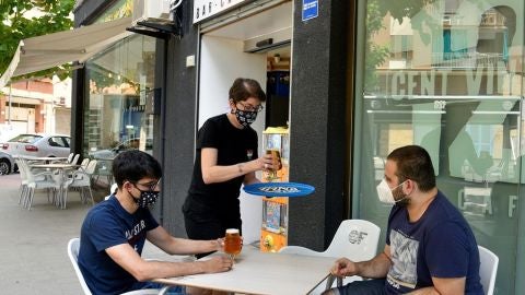 Imagen de dos j&oacute;venes con mascarilla en una terraza de Lleida