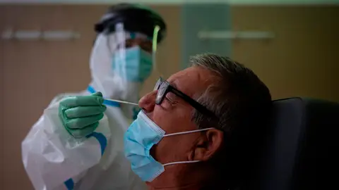 Una profesional sanitaria realiza una prueba PCR a un paciente en el CAP Raval Nord de Barcelona Una profesional sanitaria realiza una prueba PCR a un paciente en el CAP Raval Nord de Barcelona