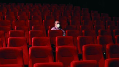 Un espectador espera el comienzo de la pel&iacute;cula en una sala de cine casi vac&iacute;a