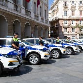 Policías locales junto a sus coches patrulla