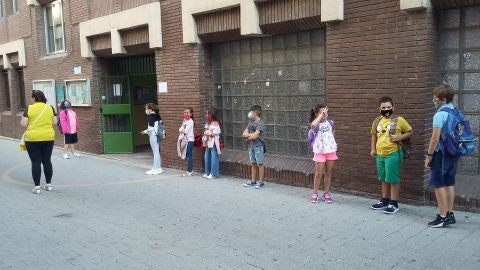 Alumnos en fila y con mascarillas antes de entrar en el colegio