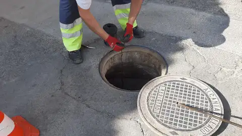 Operario trabajando en un alcantarillado Desratización