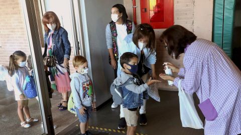 Varios ni&ntilde;os entrando al colegio con mascarilla