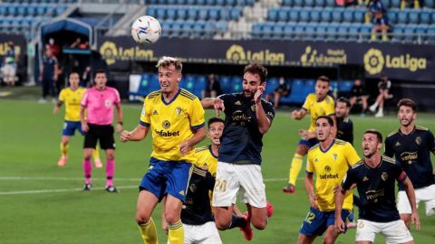 El delantero del Club Atl&eacute;tico Osasuna, Adri&aacute;n L&oacute;pez lucha por el bal&oacute;n con el centrocampista del C&aacute;diz CF, Sergio Gonz&aacute;lez.