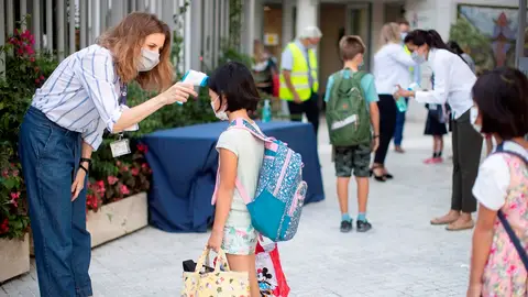 Una trabajadora toma la temperatura a una niña en un colegio de Barcelona Una trabajadora toma la temperatura a una niña en un colegio de Barcelona