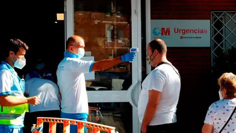 Un paramédico toma la temperatura a un ciudadano antes de acceder al centro de salud Reyes Católicos Un paramédico toma la temperatura a un ciudadano antes de acceder al centro de salud Reyes Católicos