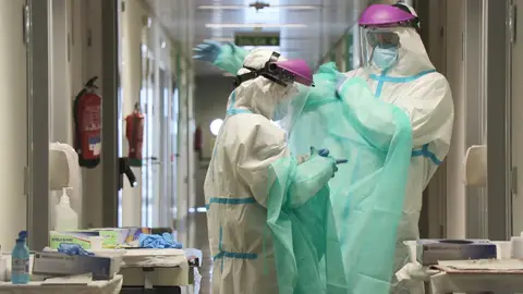 Sanitarios colocándose el traje EPI Sanitarios colocándose el traje EPI