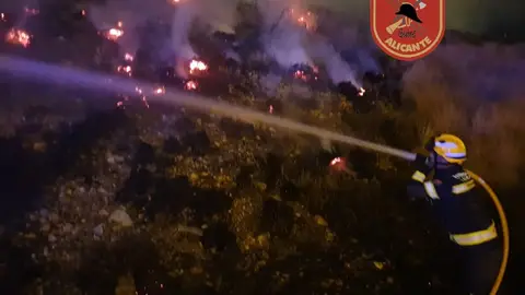Un bombero ataca el fuego Un bombero ataca el fuego