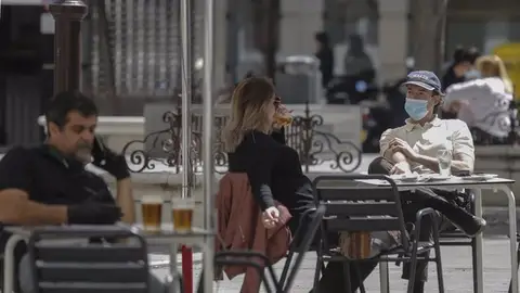 Clientes consumiendo en la terraza de un bar en horario diurno Clientes consumiendo en la terraza de un bar en horario diurno