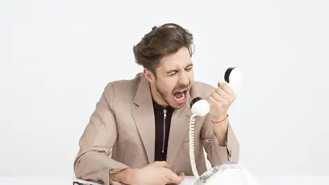 Hombre enfadado gritando al teléfono Hombre enfadado gritando al teléfono